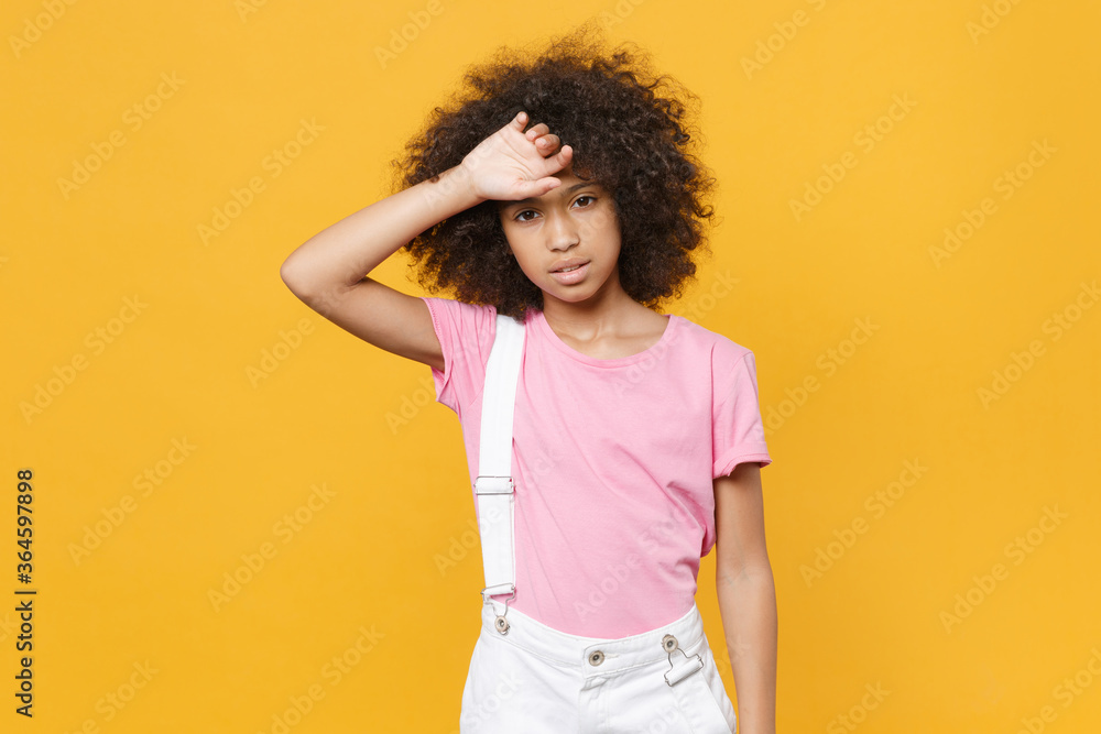 Exhausted tired little african american kid girl 12-13 years old in pink t-shirt isolated on yellow wall background studio portrait. Childhood lifestyle concept. Mock up copy space. Put hand on head. Exhausted tired little african american kid girl 12-13 years old in pink t-shirt isolated on yellow wall background studio portrait. Childhood lifestyle concept. Mock up copy space. Put hand on head.