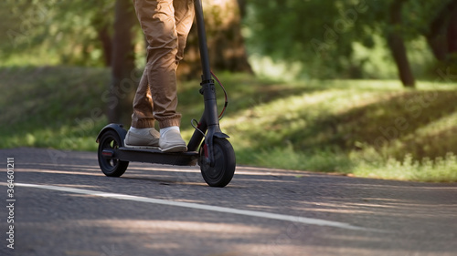 Senior man riding electric kick scooter in the park      