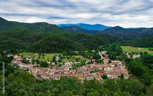 A panoramic view of an old Catalan town Sant Llorenç de la Muga with buildings on the hills of the Spanish Pyrenees mountains in winter