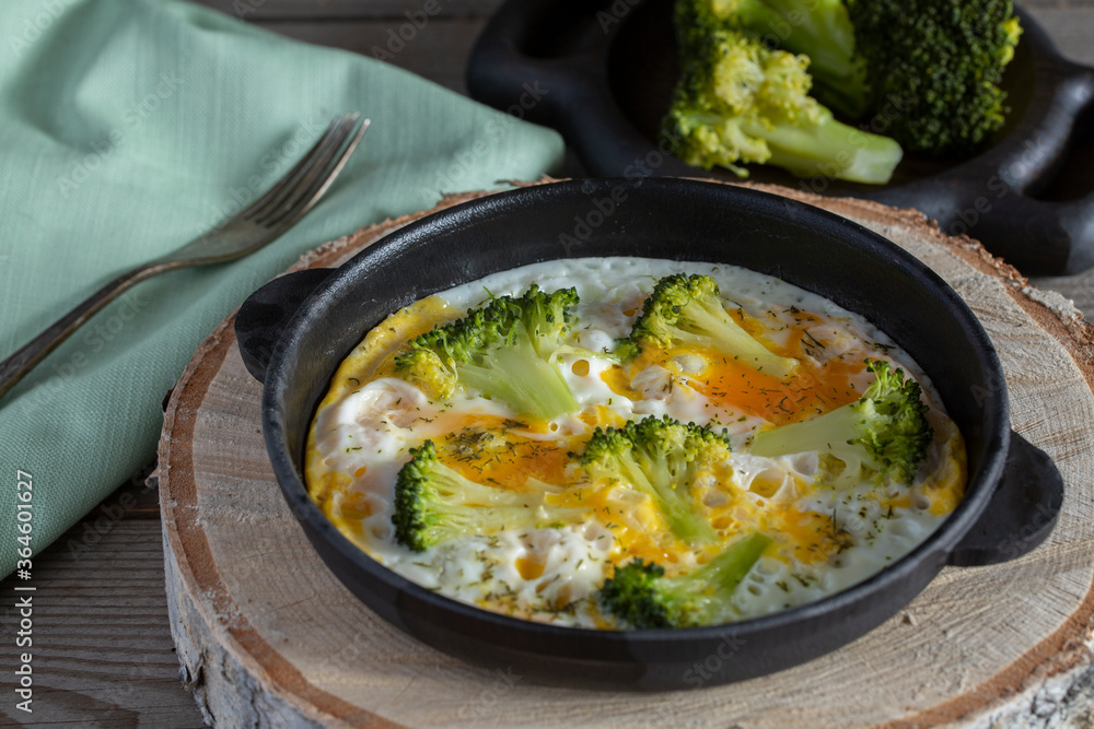 Scrambled eggs with broccoli in a cast-iron skillet. Homemade food. Healthy eating