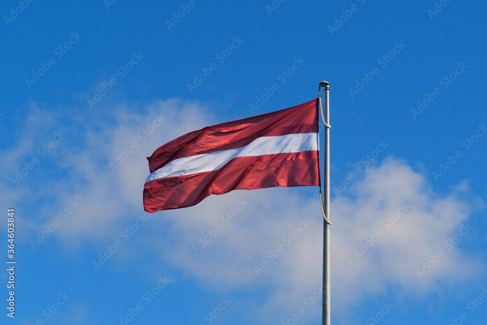 Flag of the Republic of Latvia. Flag of Latvia against the blue sky. Copy space. Flag of the Republic of Latvia. Flag of Latvia against the blue sky. Copy space.
