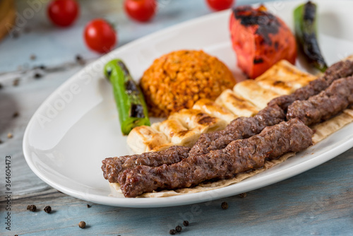 shish meatball kebab from turkish cuisine. served with white plate on wooden table.