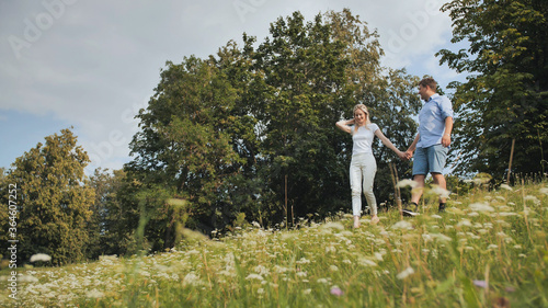 A guy and a girl walk in the park on a summer day