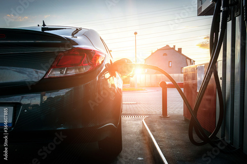 Person pumping gas. Fuel petrol for car at gasoline oil station nozzle in tank. Hand and black refueling gun close-up. © Maksym