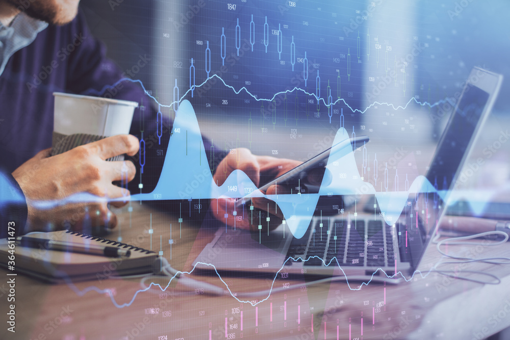 Double exposure of man's hands holding and using a phone and financial graph drawing. Analysis concept. Double exposure of man's hands holding and using a phone and financial graph drawing. Analysis concept.