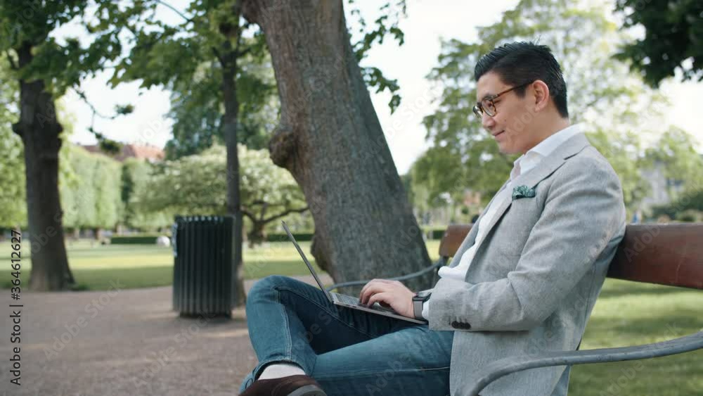Korean Businessman Using Laptop In Park Korean Businessman Using Laptop In Park