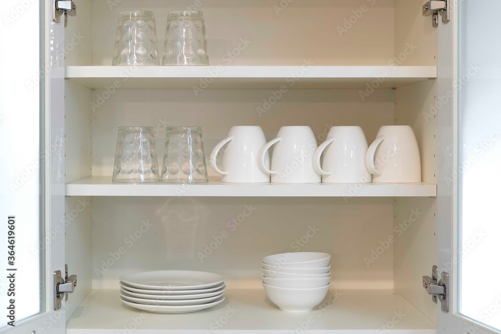 Glass and bowl are washed clean and placed in the kitchen cabinet Glass and bowl are washed clean and placed in the kitchen cabinet
