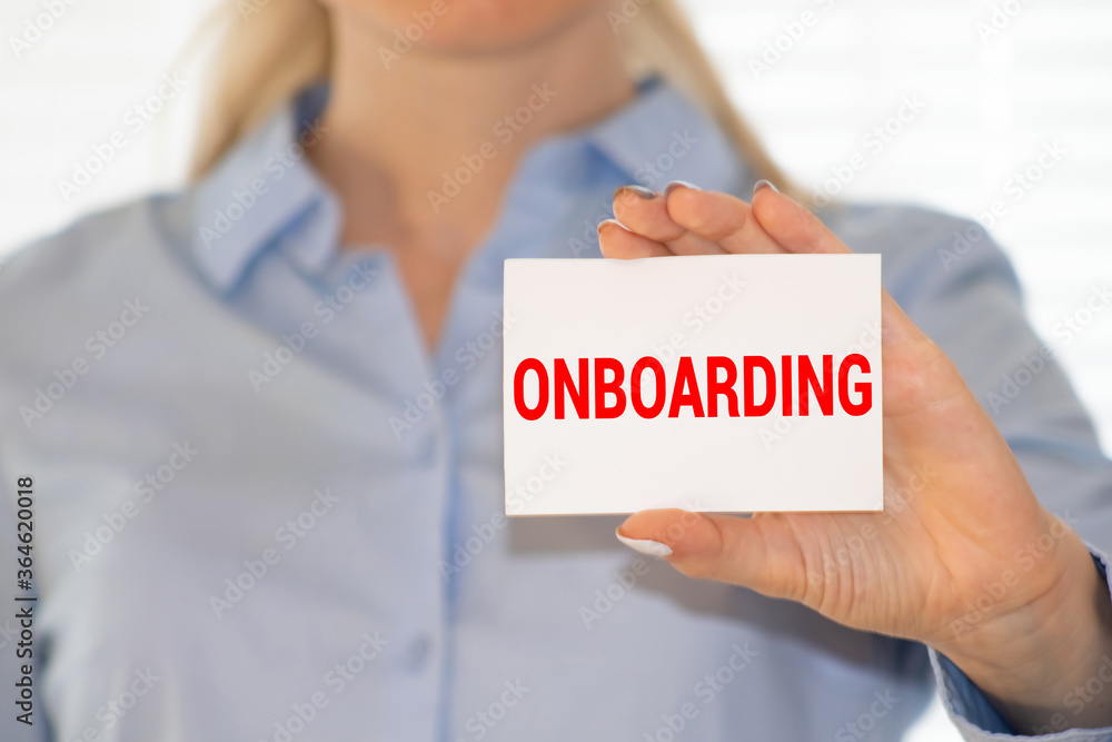 Person showing business card. Casual woman smiling holding the card. Shallow depth of field, focus on paper with ONBOARDING text. Person showing business card. Casual woman smiling holding the card. Shallow depth of field, focus on paper with ONBOARDING text.