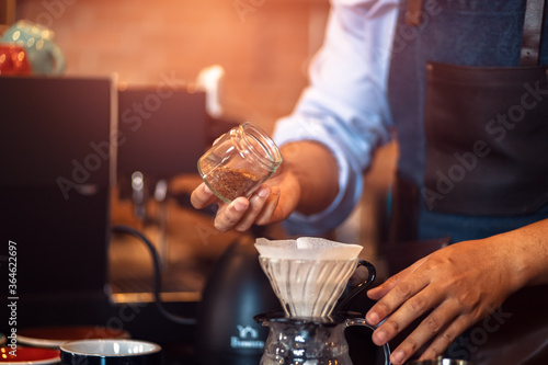 remove the beans from the bottle with a measure spoon .Measuring coffee drip with glass mug 