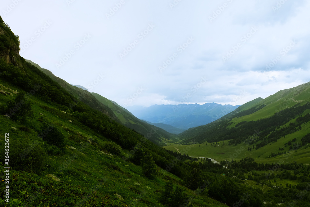 Summer mountains green grass and blue sky landscape. Caucasus mountains Summer mountains green grass and blue sky landscape. Caucasus mountains