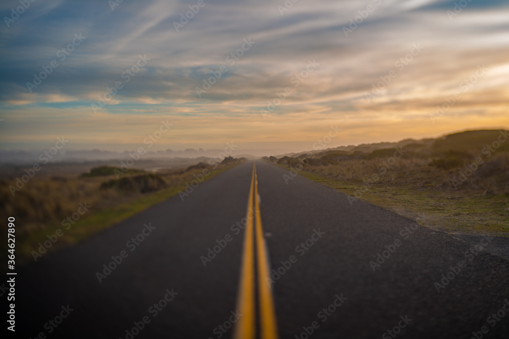 Selectively blurred road and horizon with sunset sky.