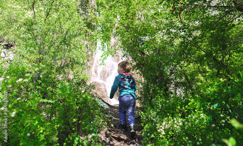 enthusiastic child goes to the waterfall