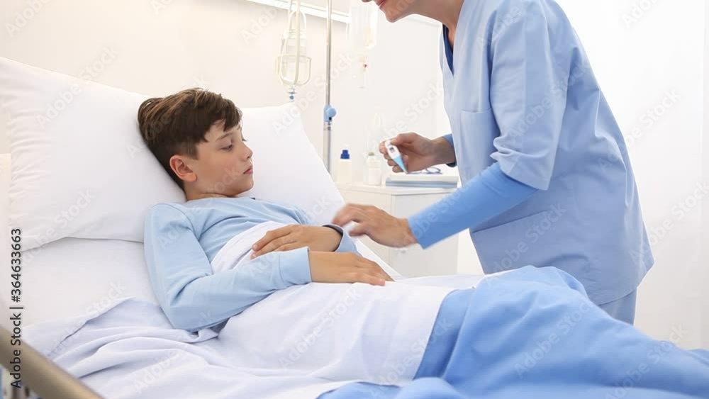 child lying in the hospital bed, nurse with thermometer measures the temperature of the fever child lying in the hospital bed, nurse with thermometer measures the temperature of the fever