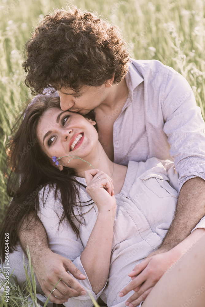 Young couple sits on grass. Happy relationship Young couple sits on grass. Happy relationship