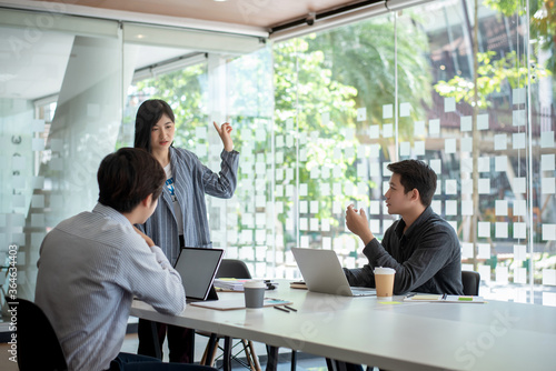 Group of young asian modern people in smart casual wear having a brainstorm meeting. Group of young asian business people discussing in the meeting.