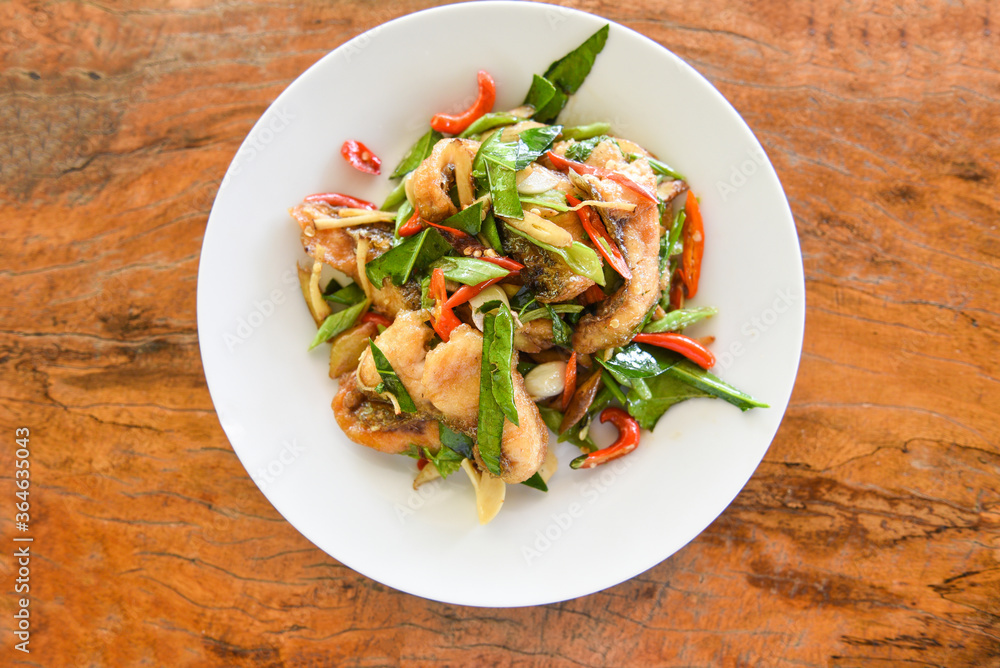 Thai food stir fried fish with pepper chili and herb on white plate - Tilapia fish cooked food Thai food stir fried fish with pepper chili and herb on white plate - Tilapia fish cooked food