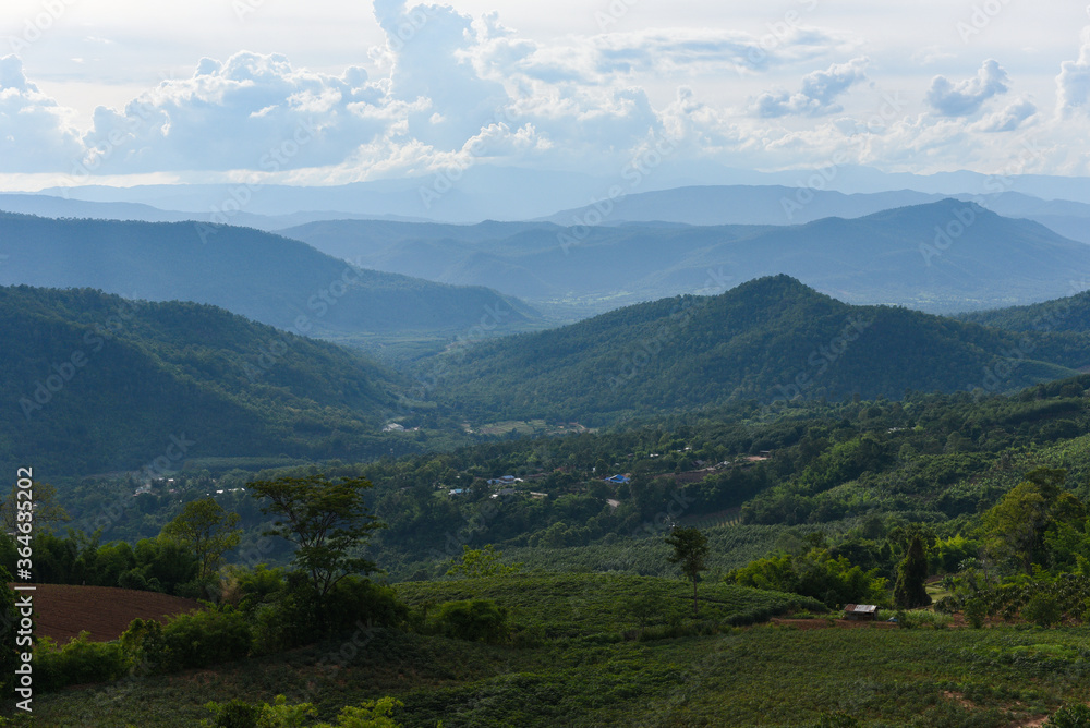 Fototapeta premium Blue mountain landscape view with the village countryside and ranch agriculture background - Tropical rain forest nature mountain landscape Thailand