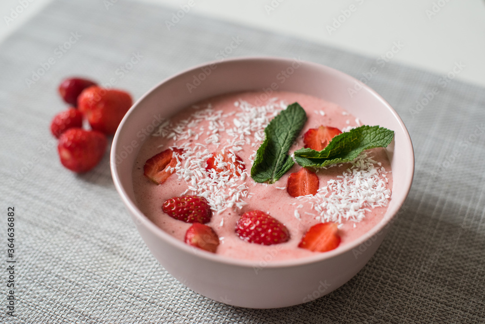 Delicious smoothie bowl in pink bowl on a grey table Delicious smoothie bowl in pink bowl on a grey table