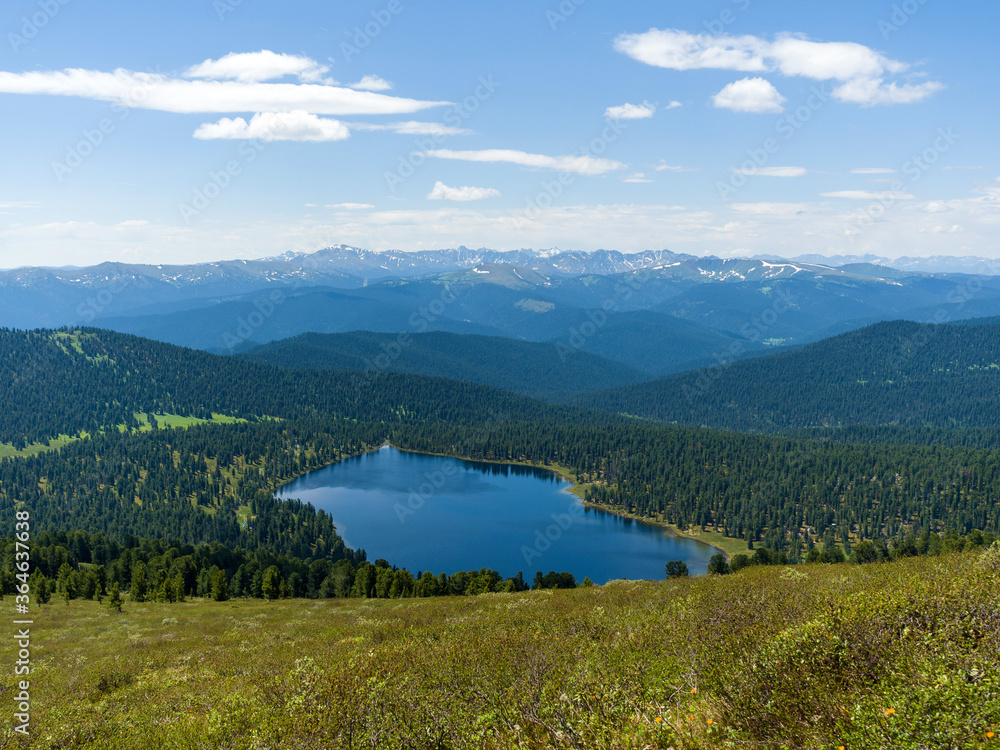 The view from the top of the mountain. Light Lake in the Ergaki Nature Park. Panorama of the distant Siberian mountains The view from the top of the mountain. Light Lake in the Ergaki Nature Park. Panorama of the distant Siberian mountains