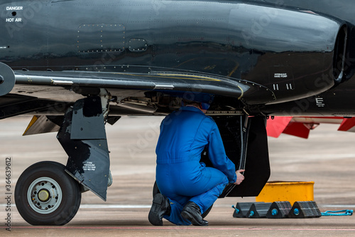 Aircraft engineer working in the undercarriage bay of a military jet trainer.