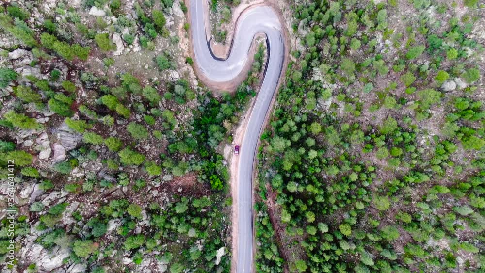 Empty driving road through Glenwood canyon switchbacks twisted lane between rocky mountains woods and green trees. Top down aerial view above highway road In Colorado, USA. No cars Empty driving road through Glenwood canyon switchbacks twisted lane between rocky mountains woods and green trees. Top down aerial view above highway road In Colorado, USA. No cars