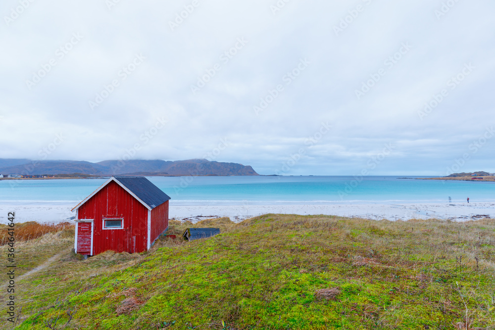 Photography Blue water at beach Rambergstranda with typical red fisher hut in Ramberg, Norwa
