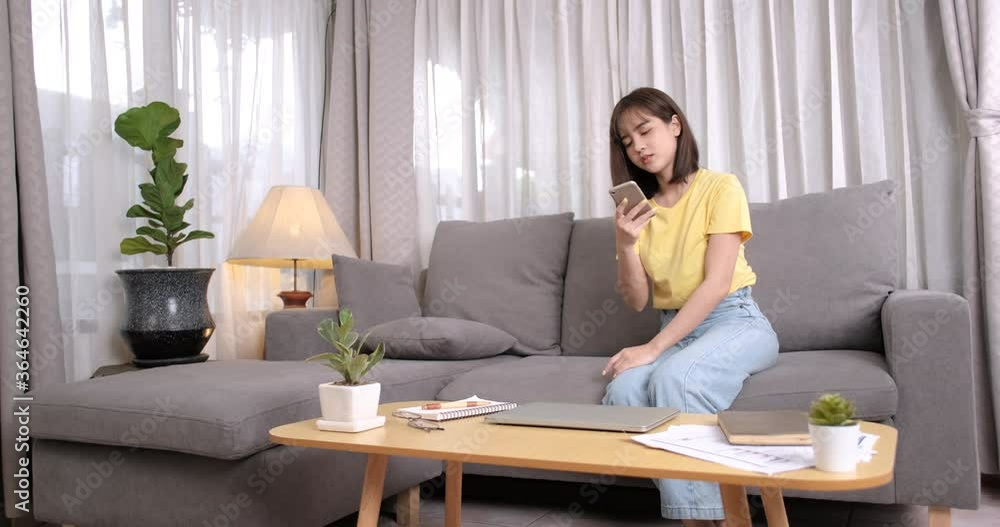 Young asian woman working open laptop computer while talking on phone. Young asian woman working open laptop computer while talking on phone.