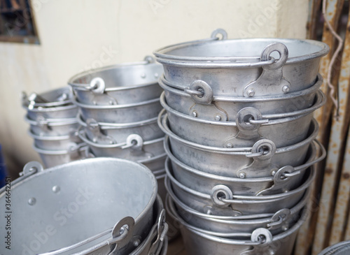 Many old aluminum ice bucket laid in wait for use. © VICHAILAO