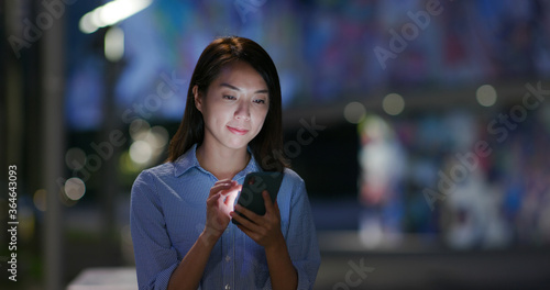 Woman work on cellphone at night