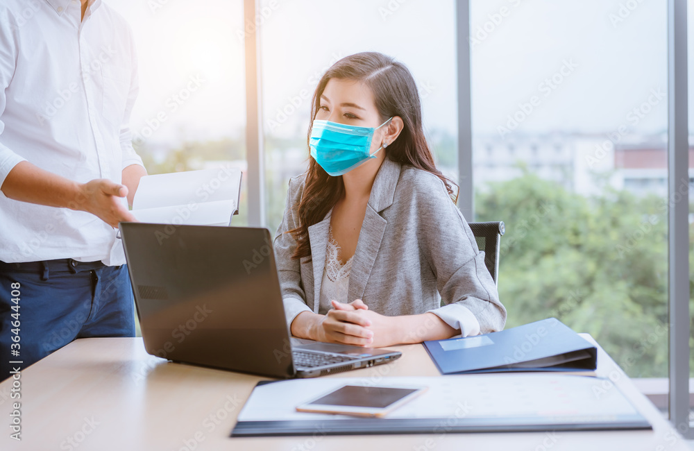 Φωτογραφία Businesswoman and partner business team work meeting are discussing with new strategy business project with laptop and file document at office,she wearing face mask to protect  virus
