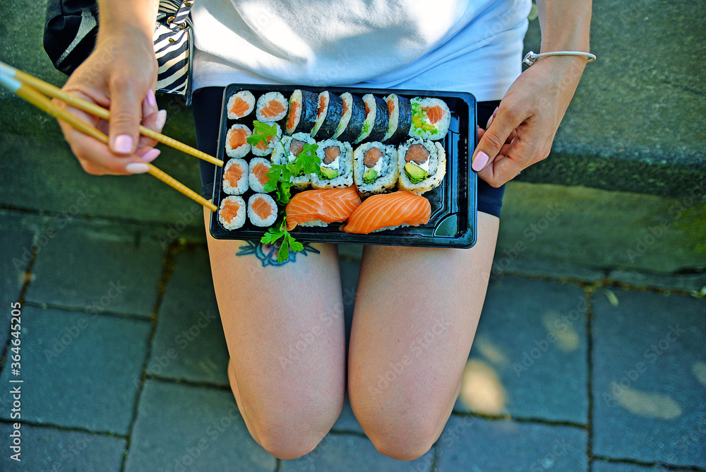 Young woman in the park whit sushi