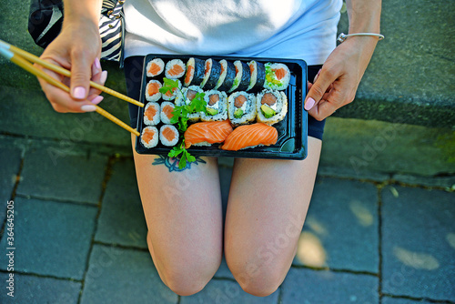 Obraz na płótnie Young woman in the park whit sushi w salonie