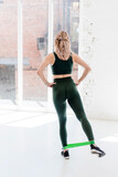 Fitness girl using resistance band for legs exercises