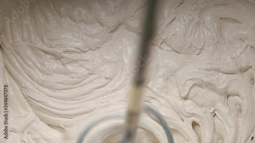 Slow motion pan shot of mixing concrete plaster with electric mixer. spatula and bucket with mortar on the construction site.