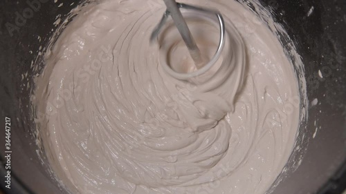 Slow motion pan shot of mixing concrete plaster with electric mixer. spatula and bucket with mortar on the construction site.
