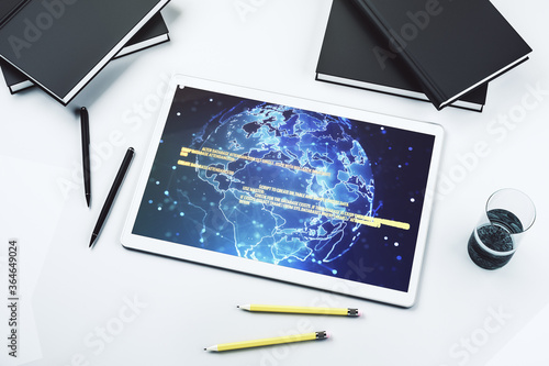 Modern digital tablet monitor with abstract creative coding sketch and world map, artificial intelligence and neural networks concept. Top view. 3D Rendering