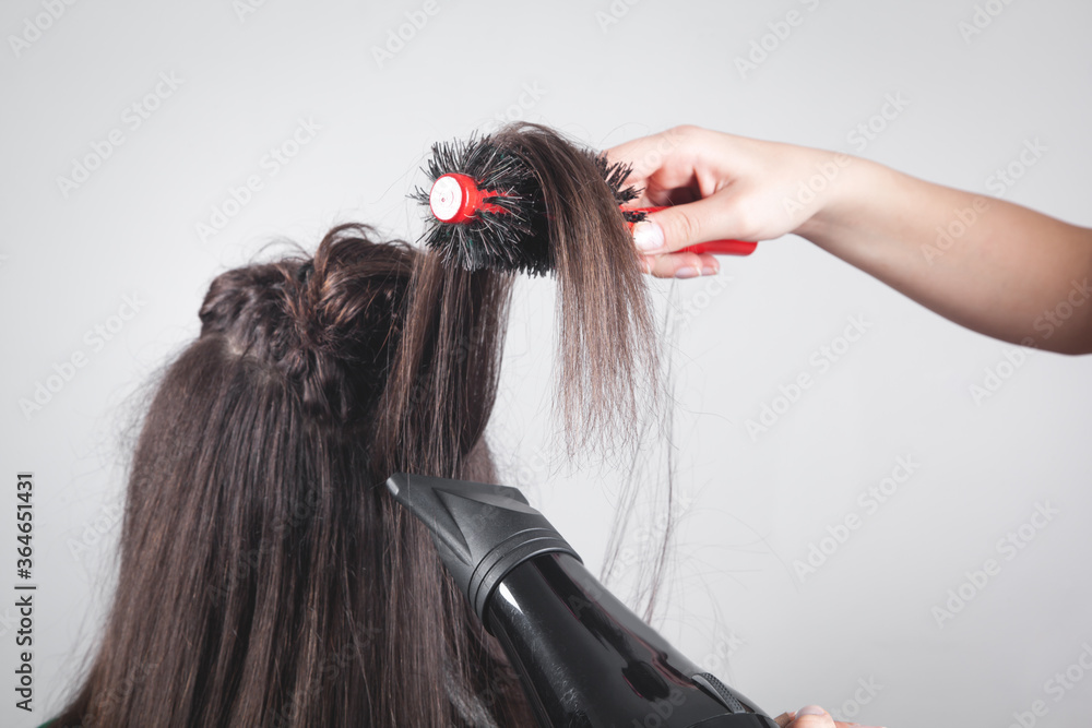 Fototapeta premium Girl drying hair with hairdryer in home.