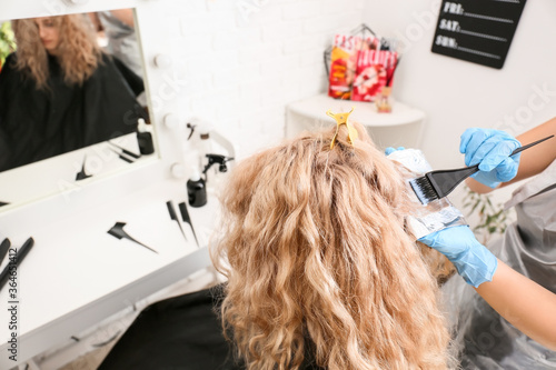 Hairdresser dyeing woman's ...