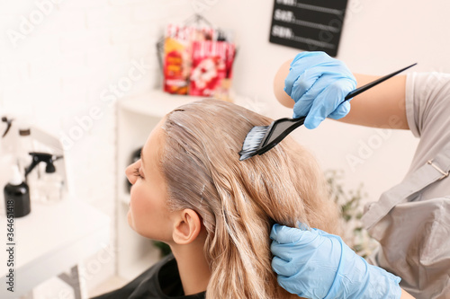 Hairdresser dyeing woman's ...