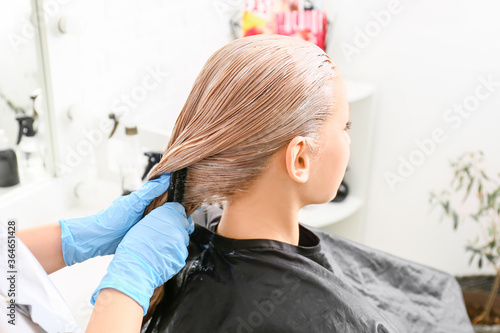 Hairdresser dyeing woman's ...