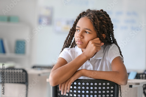 Sad African-American girl at school. Stop racism photo