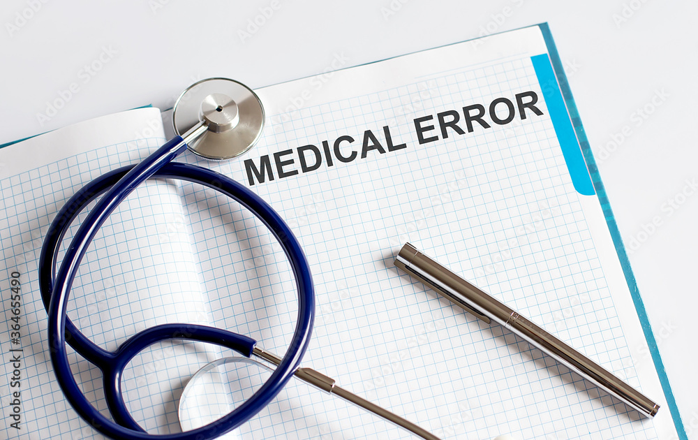 Paper with text MEDICAL ERROR on a table Paper with text MEDICAL ERROR on a table