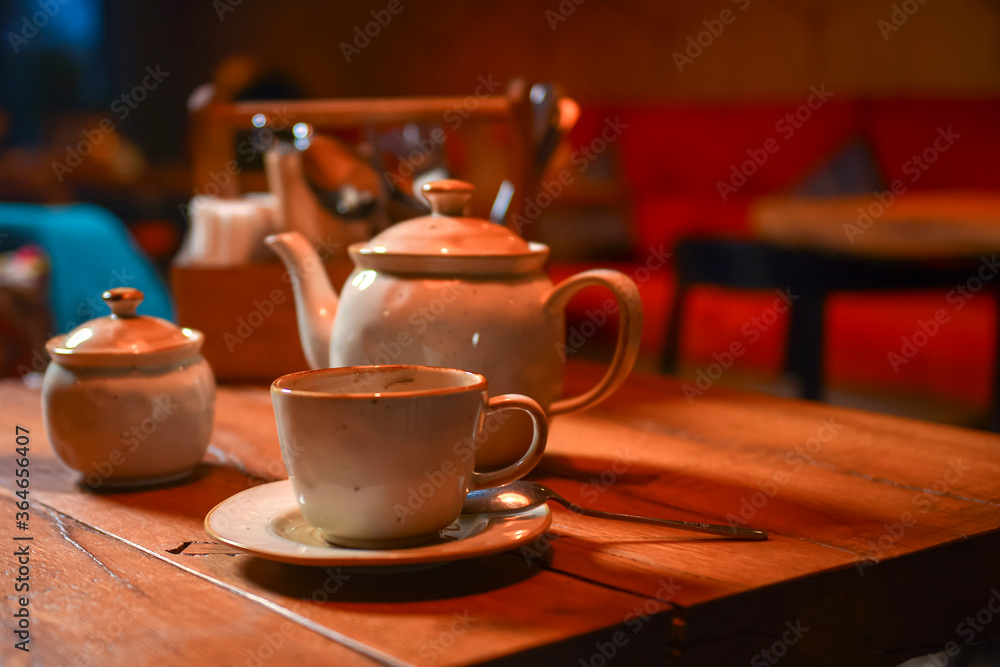White tea set served on a rustic wooden table in a restaurant. Tea time. Ceramic tea set. Eating out concept.