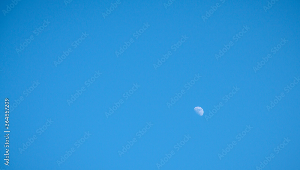 half moon on clear blue sky during the day ,with copy space half moon on clear blue sky during the day ,with copy space