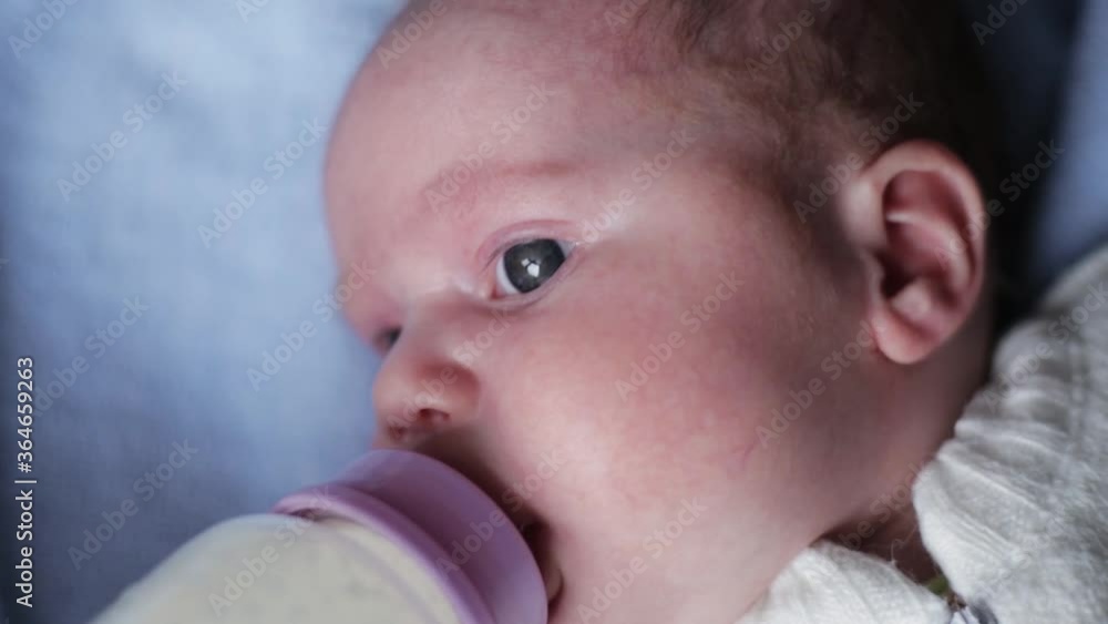 Closeup portrait of a cute little newborn baby being given milk through a feeding bottle. Closeup portrait of a cute little newborn baby being given milk through a feeding bottle.