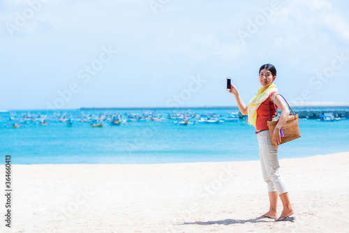 海の写真を撮る女性