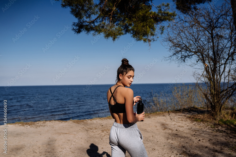 Fitness young woman walks in the park and posing for the camera