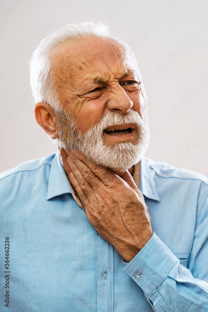 Portrait of senior man who is having pain in neck glands. Portrait of senior man who is having pain in neck glands.