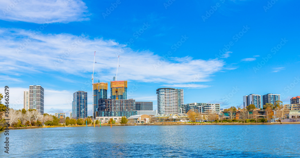Naklejka premium Panoramic view of Belconnen town centre looking across Lake Ginninderra on a sunny day in Canberra, the capital of Australia 