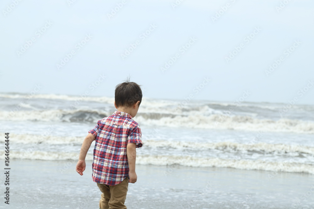 海に入っていく男の子（背中）